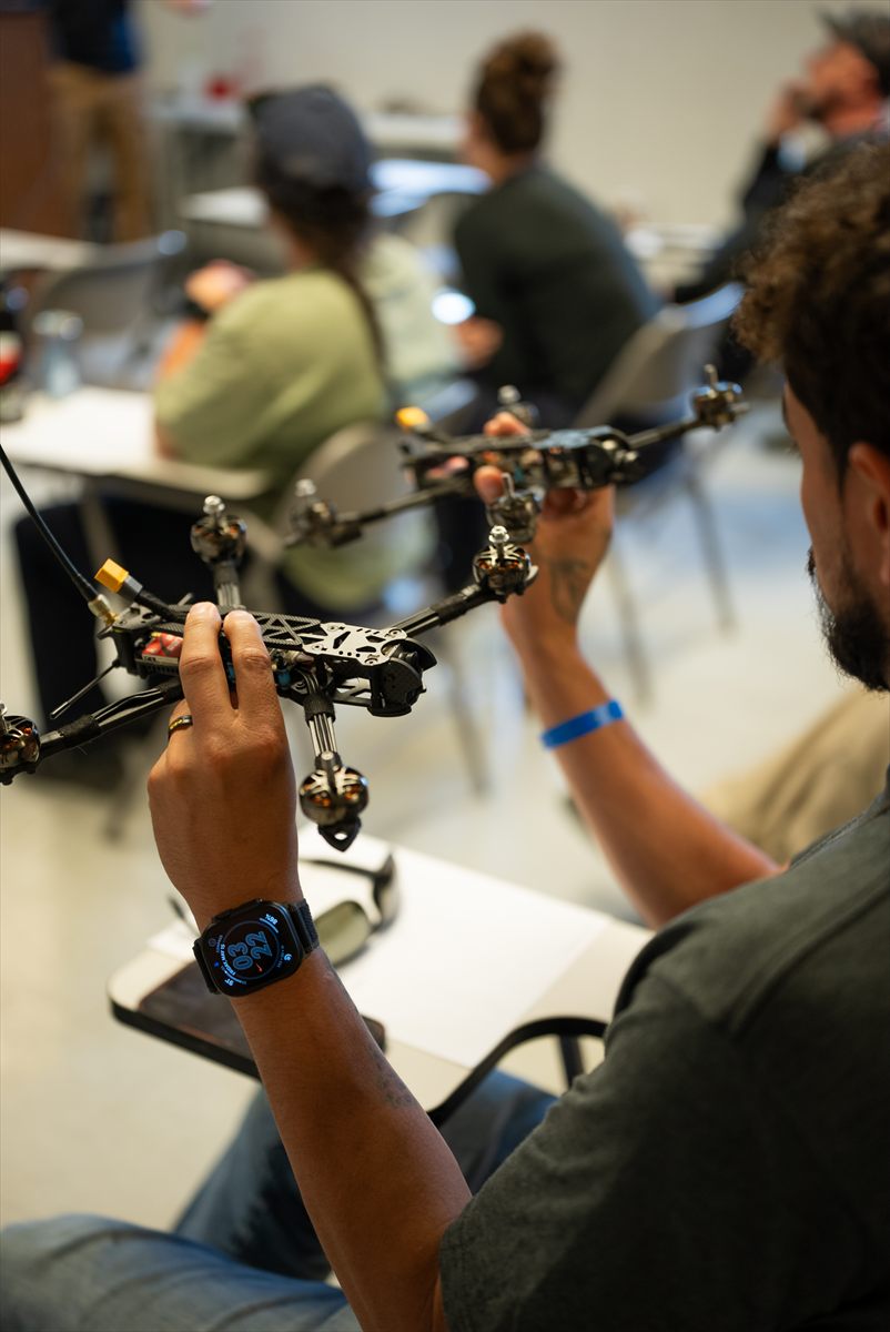 Student working with FPV drone components during training