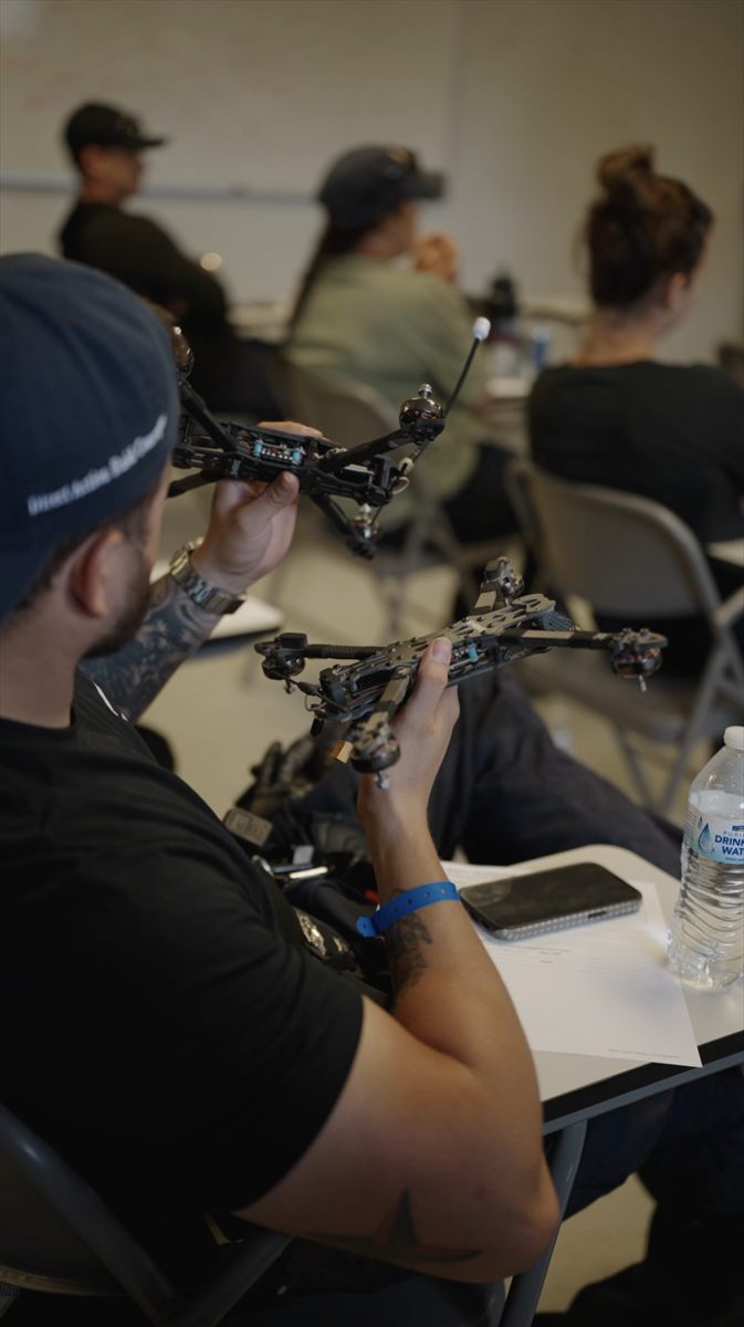 Students reviewing FPV drone equipment during training