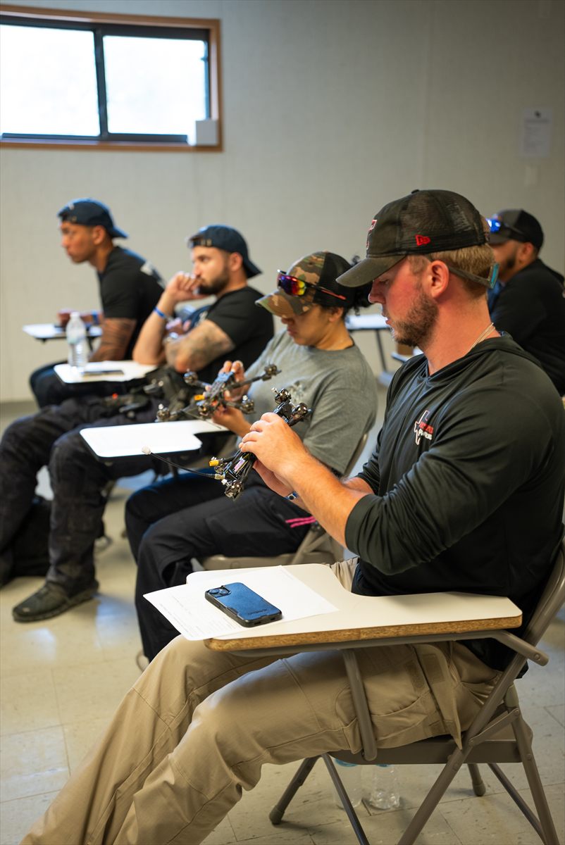 Student handling FPV drone equipment during practical training